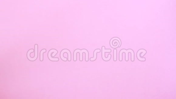 女性手把彩彩彩心彩蛋放在粉色背景的复活节彩蛋上视频的预览图
