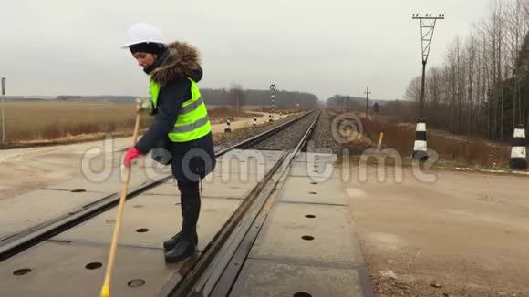 女铁路工人清洁铁路道口视频的预览图