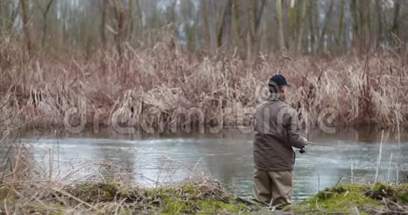 人在森林中的湖岸捕鱼视频的预览图