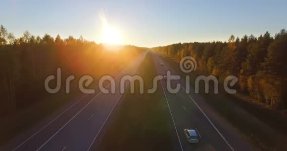 日落时沿着混合的硬木和针叶林的高速公路的空中全景视频的预览图