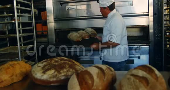 男厨师从烤箱中取出面包4k视频的预览图