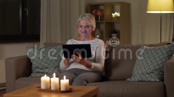 晚上在家玩平板电脑的快乐高级女性视频的预览图