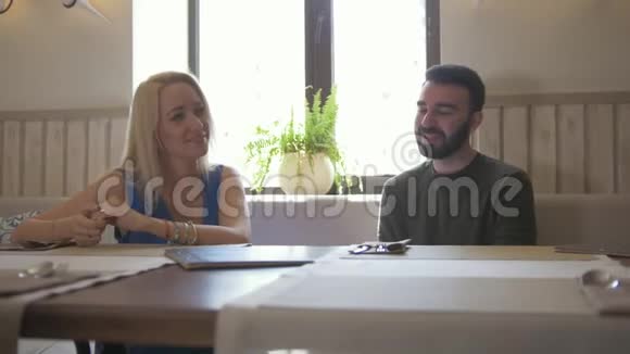 快乐的白种人夫妇在咖啡馆吃甜点和聊天视频的预览图
