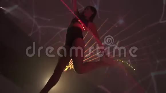 在夜总会的激光表演中美丽的体操运动员在夜间跳舞视频的预览图