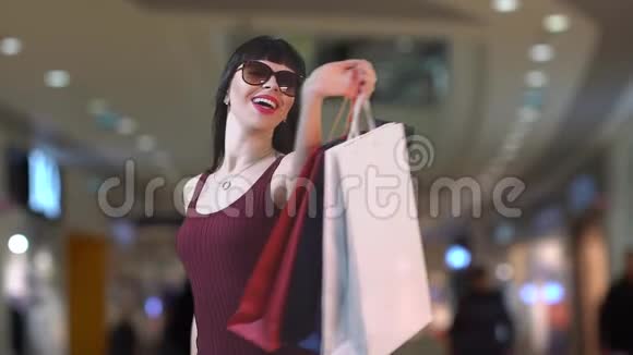 一个迷人的黑发女人对新买的东西很满意慢动作视频的预览图