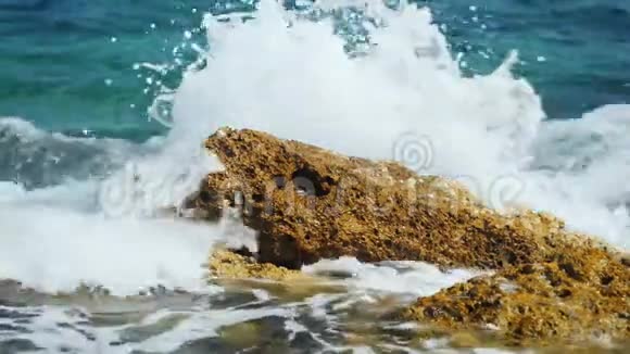 海浪拍打着岩石溅起大量的水视频的预览图