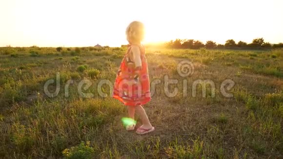 一件小女孩的衣服在夕阳的光线下旋转视频的预览图