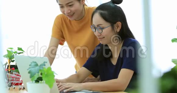 两位美丽的亚洲商界女性正在一间轻便而现代化的办公室工作视频的预览图