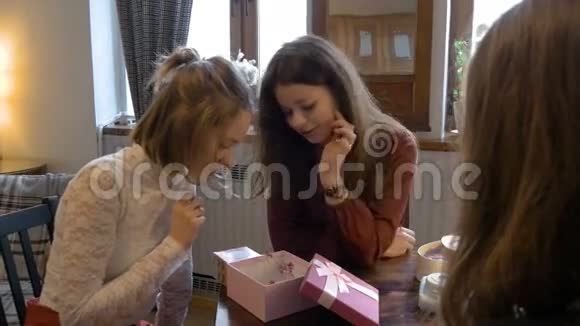 年轻漂亮的女孩互相送礼物并考虑他们视频的预览图