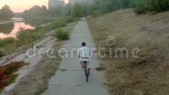 年轻人在公园骑自行车城市全景空中视频的预览图