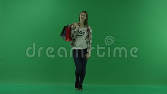 女孩站在她的肩膀上背着袋子在绿色的屏幕上微笑视频的预览图