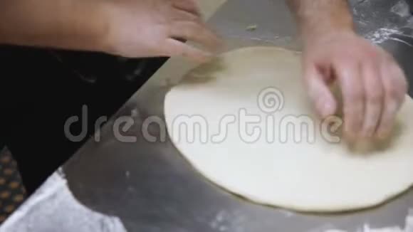 面包师熟练地滚动比萨饼面团视频的预览图