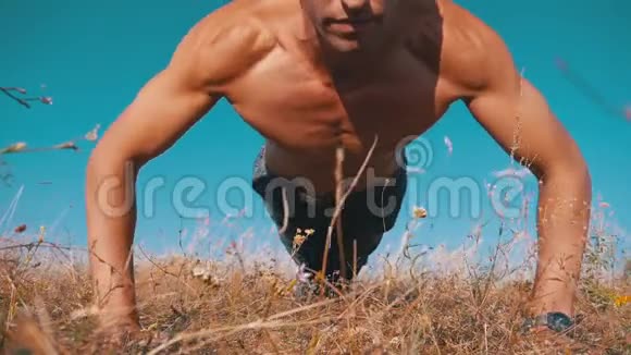 年轻的运动男子裸露的躯干进行俯卧撑的自然慢动作视频的预览图