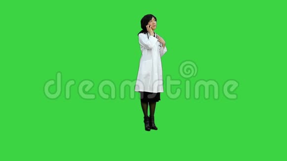 亚洲女医生在绿色屏幕上使用智能手机Chroma键视频的预览图