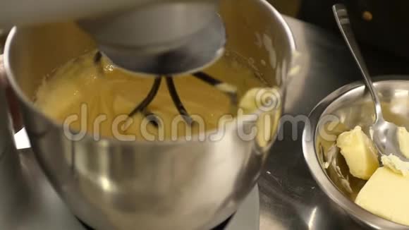 一个糖果师在碗里加入一些黄油和搅拌器视频的预览图