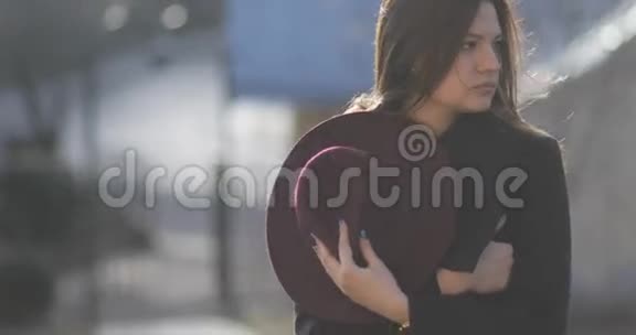 4k有魅力的年轻女孩留着长发在阳光和风的吹拂下散步戴着紫色的帽子秋装斯塔迪卡姆视频的预览图