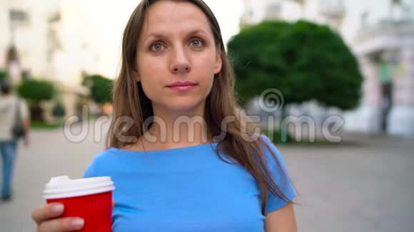快乐的女人在繁忙的街道上喝咖啡视频的预览图