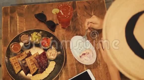 年轻的嬉皮士混合种族女孩吃冰淇淋与勺子4K咖啡厅提供美味的素食甜点视频的预览图
