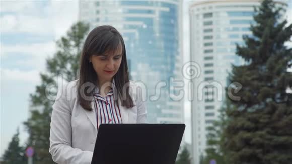 女商人在城市公园里用笔记本电脑视频的预览图