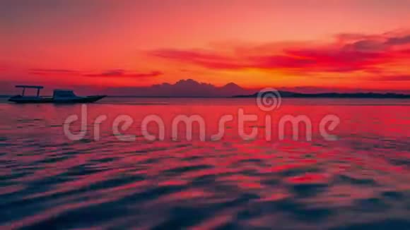 印度尼西亚阿贡火山和船的背景上大海中永恒的彩色日落视频的预览图