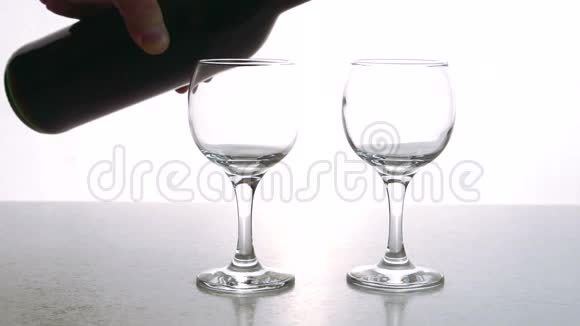 这两个水晶酒杯正在餐厅的酒吧里用带有浓郁花团锦簇的红干葡萄酒来完成视频的预览图