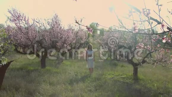 可爱的女孩站在盛开的花园里视频的预览图