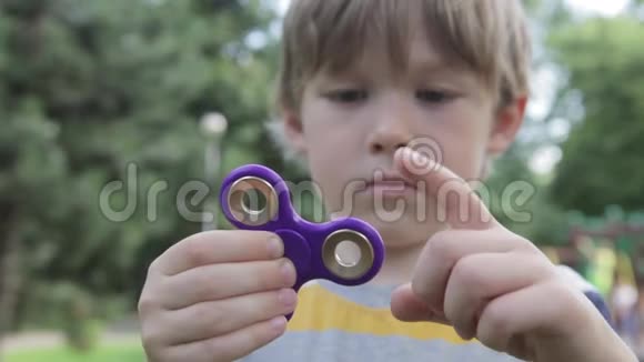 一个小男孩在玩旋转器那个男孩手里拿着旋转器视频的预览图