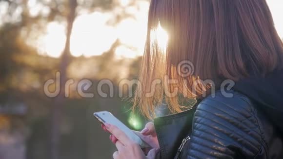 迷人的年轻女孩站在繁忙的嗡嗡声城市中的夏季日落阳光灿烂的年轻女子视频的预览图