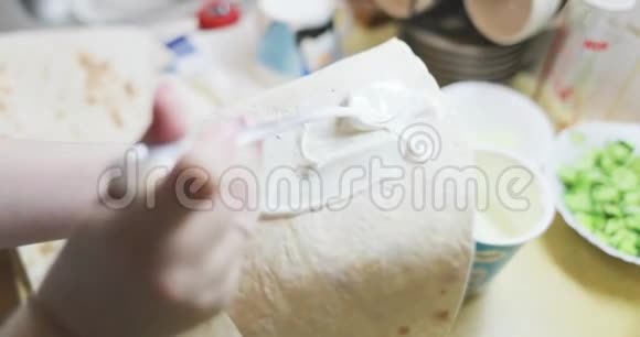 手拿皮塔面包用酱汁涂抹视频的预览图