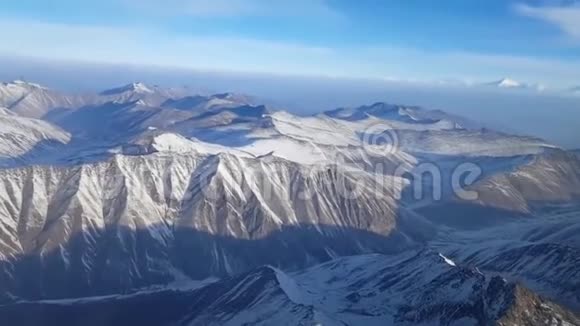 奇妙的空中无人机拍摄雪覆盖石岩山顶山崖大链山脉冬季云景视频的预览图