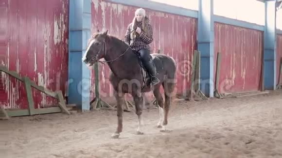 年轻女子在马厩里骑马视频的预览图