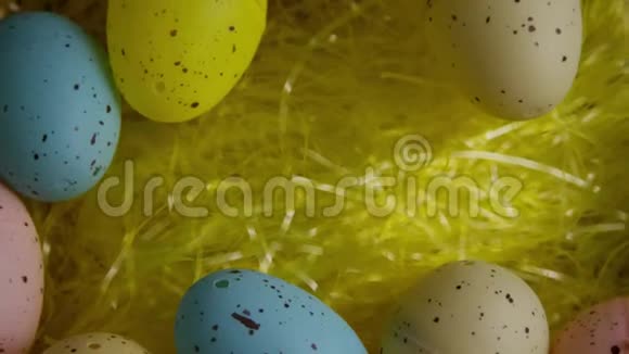 在五颜六色的复活节草地上旋转复活节装饰品和糖果的镜头视频的预览图