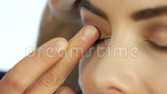 化妆师在他的眼睛下面画一个矫正器为美容院的美女化妆视频的预览图
