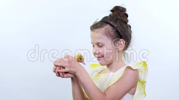 肖像一个漂亮可爱的小女孩和一只黄色的小鸭子玩白底演播室录像视频的预览图