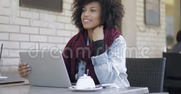 微笑的女人在咖啡馆里浏览笔记本电脑视频的预览图