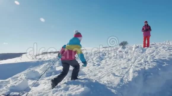 幸福的家庭母亲和孩子女儿在户外散步雪橇妈妈和孩子们的美丽家庭视频的预览图