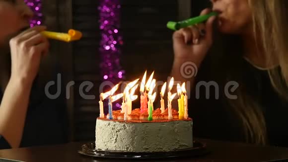 两个喜怒无常的女人吹灭了生日蛋糕上的蜡烛蜡烛熄灭了慢动作视频的预览图
