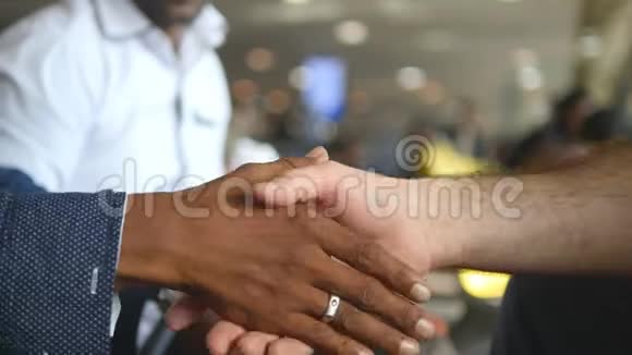 办公室里的多种族握手商务人员在机场候机楼互相问候男性手臂颤抖同事视频的预览图