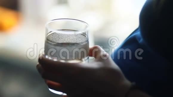 穿着蓝色夹克衫的孕妇在家喝药片吃药洗一杯水视频的预览图