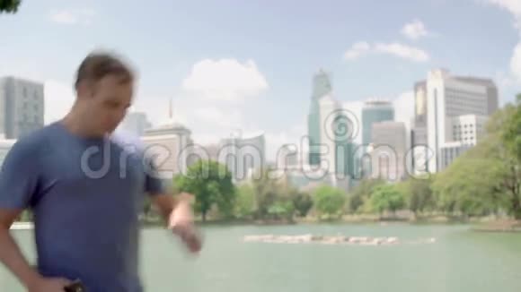 男跑运动员在公园慢跑适合男性运动健身训练在他的智能手机上自拍视频的预览图