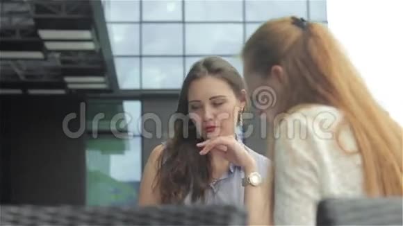 两位同事在户外咖啡馆谈生意视频的预览图