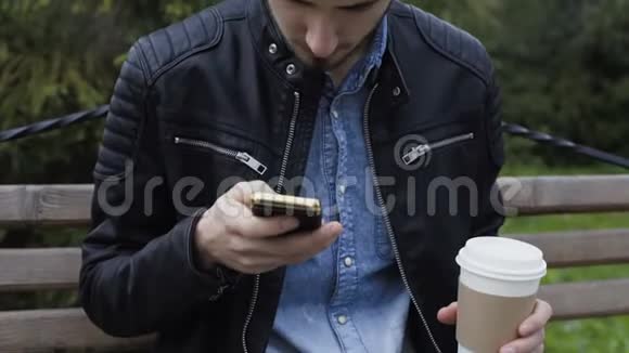 英俊的男性模特在新鲜的秋天公园喝咖啡视频的预览图