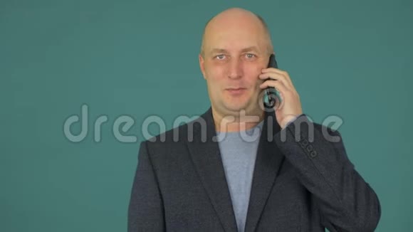 肖像成年男子在绿色背景下用手机交谈视频的预览图