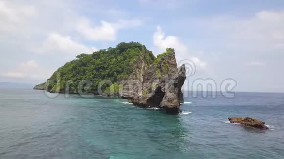 在印度尼西亚努沙佩尼达的阿图海滩绕着美丽的岩拱岛飞行4飞机视频的预览图