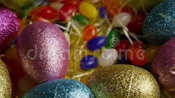 在五颜六色的复活节草地上旋转复活节装饰品和糖果的镜头视频的预览图