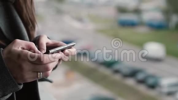 近距离观看女性手握智能手机年轻女性从手机外面浏览互联网视频的预览图