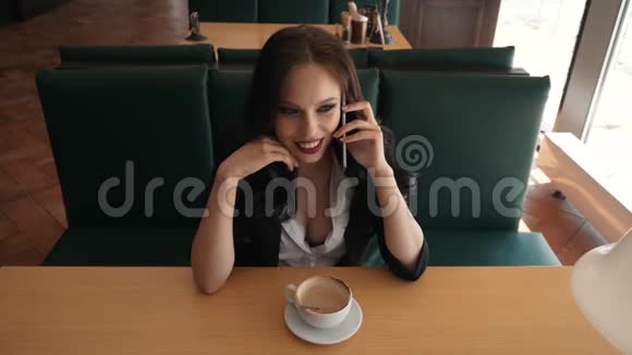 女商人站在咖啡馆打电话视频的预览图