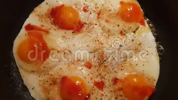 用热香料和辣椒片在平底锅中烹制新鲜鸡蛋视频的预览图