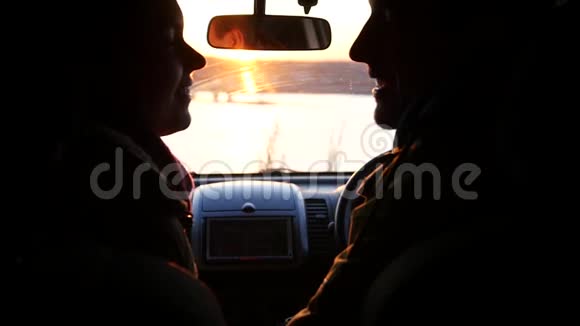 日落时分男人和女人坐在车里亲吻和微笑慢动作1920x1080全高清视频的预览图