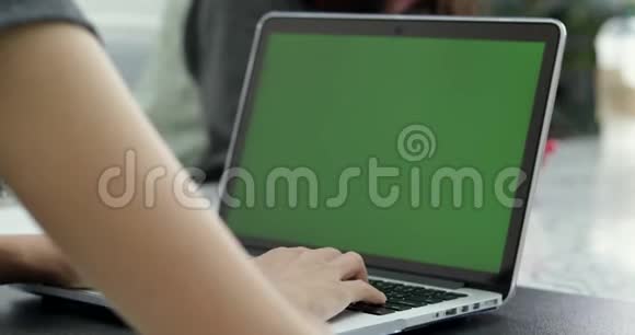 亚洲女性办公室雇员在她的桌面工作在一个模拟绿色屏幕笔记本电脑视频的预览图